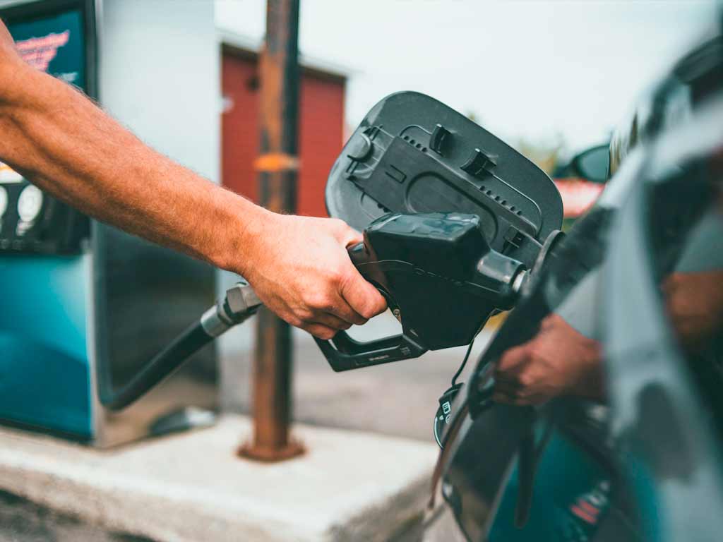 onductor repostando gasolina en estación de servicio para ahorrar en carburante.