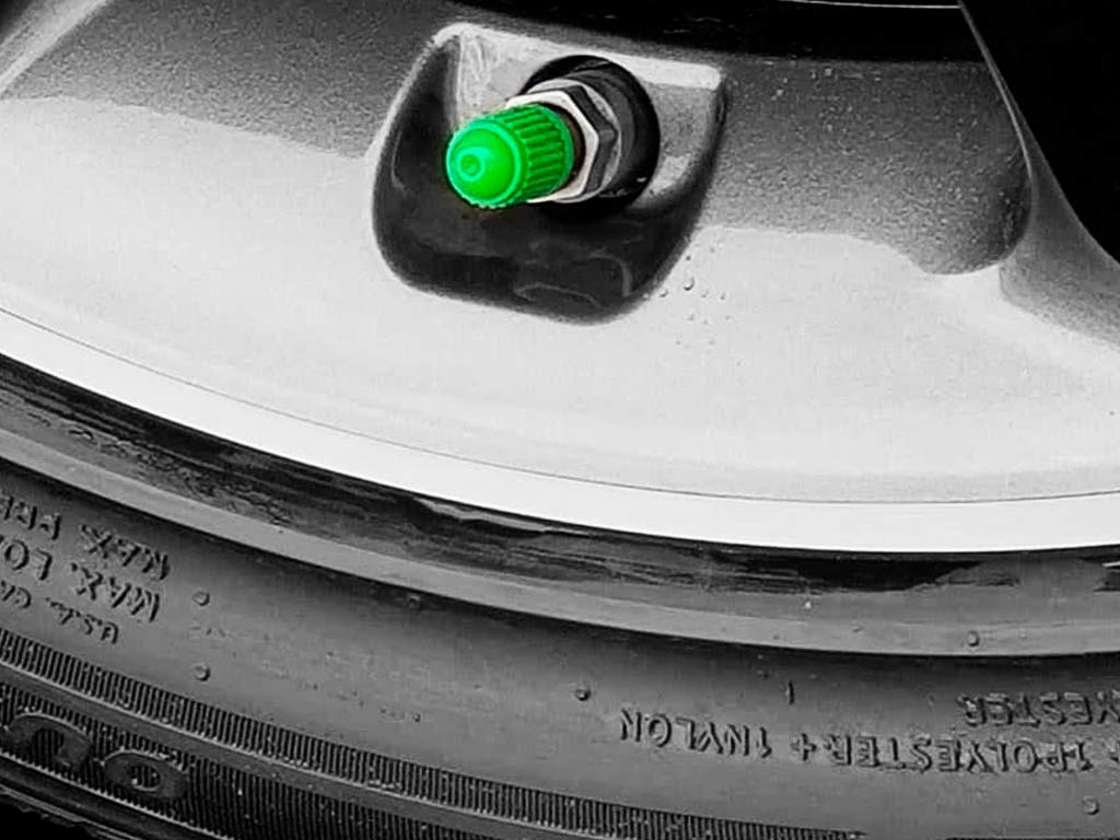 tapón verde en la rueda de un coche indicando neumático inflado con nitrógeno