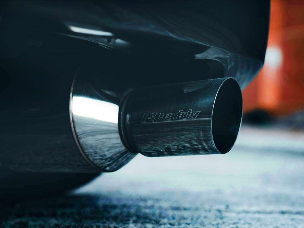 Emisiones de CO₂ saliendo del tubo de escape de un coche de combustión.