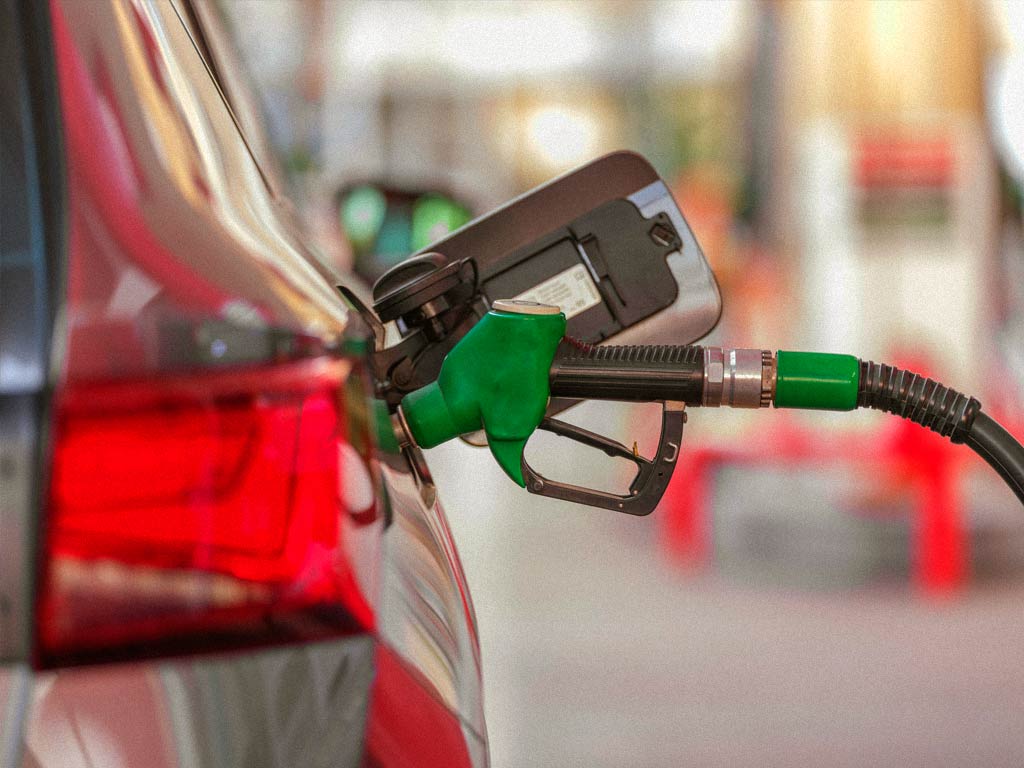 Manguera de combustible repostando en una gasolinera